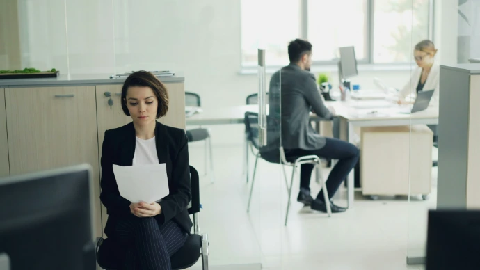 Woman sitting in office holding papers